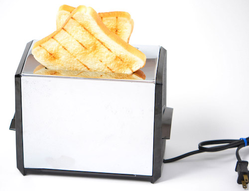 A toaster with slices of bread at the top.